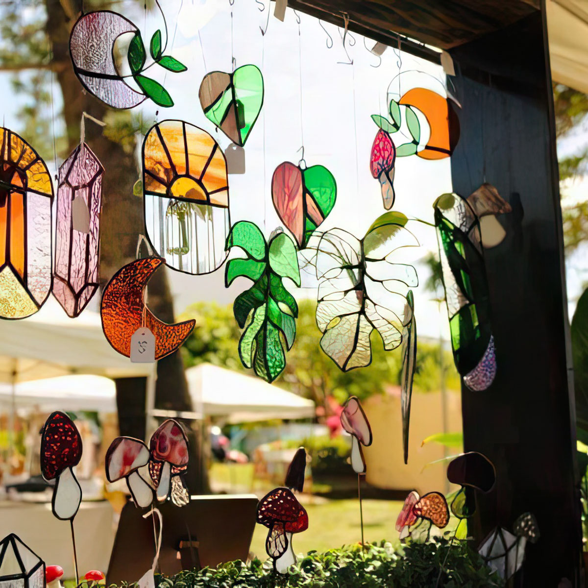 Stained glass ornaments hanging at a market stall - Tammy Peach - Stained Glass Greenhouse